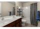 Well-lit bathroom with double sinks, granite counters and shower-tub combo at 9660 Godwin St, Ladson, SC 29456