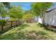 Fenced backyard with green grass, mature shade trees, and lush landscaping at 99 Shadowmoss Pkwy, Charleston, SC 29414