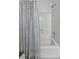 White bathtub and shower combination featuring a patterned blue leaf shower curtain at 99 Shadowmoss Pkwy, Charleston, SC 29414