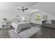 Bright bedroom with white walls, ceiling fan, wood-look flooring, and a sitting area with a gray sofa at 99 Shadowmoss Pkwy, Charleston, SC 29414