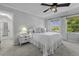 Bright bedroom with a ceiling fan, white bedding, and natural light from large windows at 99 Shadowmoss Pkwy, Charleston, SC 29414
