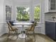 A dining area with a white table and wicker chairs nestled in a sunlit bay window at 99 Shadowmoss Pkwy, Charleston, SC 29414