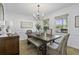 Elegant dining room with a wooden table, chandelier, and natural light from the windows at 99 Shadowmoss Pkwy, Charleston, SC 29414