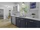 A kitchen with stainless steel dishwasher, white countertops, blue cabinets, and hardwood floors at 99 Shadowmoss Pkwy, Charleston, SC 29414