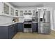 A kitchen with stainless steel appliances, white cabinets, blue cabinets, and hardwood floors at 99 Shadowmoss Pkwy, Charleston, SC 29414