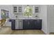 A kitchen with stainless steel dishwasher, white countertops, blue cabinets, and hardwood floors at 99 Shadowmoss Pkwy, Charleston, SC 29414