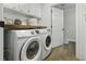 A laundry room with new Samsung washer and dryer, white cabinets and hardwood floors at 99 Shadowmoss Pkwy, Charleston, SC 29414