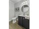 A powder room with black vanity, gold hardware, framed art and modern fixtures at 99 Shadowmoss Pkwy, Charleston, SC 29414