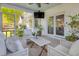 A screened porch with a seating area with white wicker furniture, a ceiling fan, and access to the backyard at 99 Shadowmoss Pkwy, Charleston, SC 29414