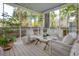 A screened porch with a seating area with white wicker furniture and a view of trees at 99 Shadowmoss Pkwy, Charleston, SC 29414