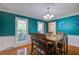 Bright dining room with hardwood floors, large windows, wainscoting, and stylish chandelier at 101 N Warwick Trce, Goose Creek, SC 29445