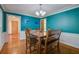 Dining room is highlighted by hardwood floors, chair railing, teal walls, stylish light fixture, and furniture at 101 N Warwick Trce, Goose Creek, SC 29445