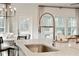 Close-up of a kitchen island with a stainless steel sink and views of the living space at 1024 Sagegrass St, Summerville, SC 29485