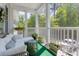 Inviting porch with white columns, white seating, and a lovely view of surrounding greenery at 106 Pickering Ln, Charleston, SC 29414