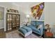 Inviting sitting room featuring a teal sofa, unique artwork, and a wooden bookcase for relaxation at 106 Pickering Ln, Charleston, SC 29414