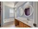 Bright blue bathroom with a bathtub, a window, and a vanity with dual circular mirrors at 109 E Hartwick Ln, Goose Creek, SC 29445