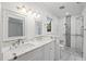 Bright bathroom featuring double sinks, marble countertops, and glass-enclosed shower with unique tiling at 109 Red Cypress Dr, Goose Creek, SC 29445