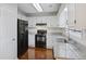 Functional kitchen showcasing granite countertops, laminate floors, and black appliances at 109 Red Cypress Dr, Goose Creek, SC 29445