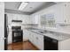 Well-lit kitchen with white cabinets, granite countertops, black appliances, and hardwood floors at 109 Red Cypress Dr, Goose Creek, SC 29445