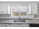 Closeup of the kitchen sink area featuring granite counters and laminate floors at 109 Red Cypress Dr, Goose Creek, SC 29445