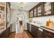 Elegant bar area with custom cabinetry, lighting, and a beverage cooler near kitchen at 1106 Meadowcroft Ln, Mount Pleasant, SC 29464