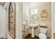 Elegant powder room featuring pedestal sink, ornate mirror and tasteful decor at 1106 Meadowcroft Ln, Mount Pleasant, SC 29464