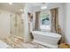 Bright bathroom boasts a freestanding tub, a glass shower, and marble-patterned floors at 1106 Meadowcroft Ln, Mount Pleasant, SC 29464