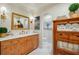 Elegant bathroom with wood cabinets, white marble countertops, and decorative sconces at 1106 Meadowcroft Ln, Mount Pleasant, SC 29464
