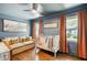 Cozy bedroom with a couch, crib, hardwood floors, and serene blue walls at 1106 Meadowcroft Ln, Mount Pleasant, SC 29464