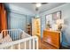 Comfortable bedroom with hardwood floors, crib, dresser, and soothing blue walls at 1106 Meadowcroft Ln, Mount Pleasant, SC 29464
