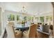 Sunlit dining room with round table, chairs, and large windows overlooking the yard at 1106 Meadowcroft Ln, Mount Pleasant, SC 29464