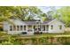 Rear exterior view of a charming white home with a porch and well-kept lawn at 1106 Meadowcroft Ln, Mount Pleasant, SC 29464