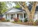 Charming one-story home with a covered front porch and beautiful landscaping under a large tree at 1106 Meadowcroft Ln, Mount Pleasant, SC 29464