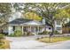 Charming one-story home with a well-manicured lawn and beautiful landscaping under a large tree at 1106 Meadowcroft Ln, Mount Pleasant, SC 29464
