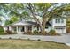 Charming one-story home with a well-manicured lawn, a covered front porch, and beautiful landscaping at 1106 Meadowcroft Ln, Mount Pleasant, SC 29464