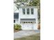 Attached garage with carriage doors and lantern sconces on a well-manicured lot at 1106 Meadowcroft Ln, Mount Pleasant, SC 29464