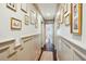 Hallway decorated with framed art, wainscoting, wood floors and rug, leading to rooms at 1106 Meadowcroft Ln, Mount Pleasant, SC 29464