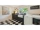 Charming laundry room with black and white floors, farm sink, and modern washer and dryer at 1106 Meadowcroft Ln, Mount Pleasant, SC 29464