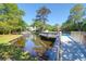Scenic view of a community pool and tranquil pond, connected by a wooden bridge at 1136 Shadow Lake Cir # 54, Mount Pleasant, SC 29464