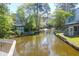 Picturesque water view of a community, with lush trees and charming residential buildings along the canal at 1136 Shadow Lake Cir # 54, Mount Pleasant, SC 29464