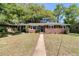 Charming brick home featuring a manicured front lawn and a walkway leading to a blue front door at 1142 Camden St, North Charleston, SC 29405