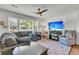 Cozy living room with large windows, comfortable seating, and a stylish ceiling fan at 1142 Camden St, North Charleston, SC 29405