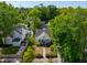 Aerial view of a home with a flower-filled front yard, lush landscaping, and swimming pool at 115 Peachtree St, Charleston, SC 29403