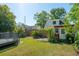 Lush backyard with a red shed, wooden fence, shade trees, and space to relax and unwind at 115 Peachtree St, Charleston, SC 29403