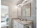 Bright bathroom with double vanity, granite counters, modern lighting, wallpaper and bedroom access at 115 Peachtree St, Charleston, SC 29403