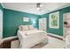 Bedroom featuring green walls, window with natural light, ceiling fan, and white shelving at 115 Peachtree St, Charleston, SC 29403