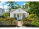 Charming cottage-style home with a picket fence and blooming pink roses bordering the walkway at 115 Peachtree St, Charleston, SC 29403