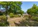 Lush front yard featuring mature trees, flowering bushes, and a quaint picket fence, creating a serene setting at 115 Peachtree St, Charleston, SC 29403