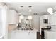 Modern kitchen featuring white cabinetry, granite countertops, stainless steel appliances, and stylish pendant lighting at 115 Peachtree St, Charleston, SC 29403