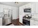 Modern kitchen featuring stainless steel appliances, white cabinets and subway tile backsplash, and wood floors at 115 Peachtree St, Charleston, SC 29403